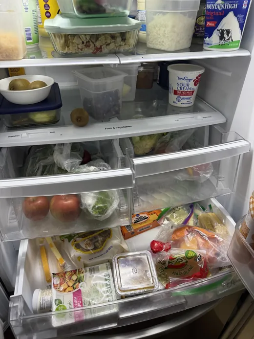 A phone photo of a full fridge